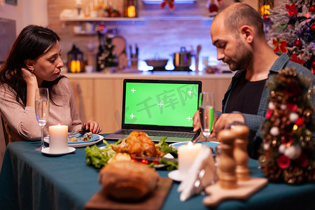 幸福的家庭看着绿屏模拟带有独立显示屏的色键平板电脑