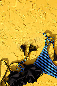 旅游杂志摄影照片_蓝色与黑色条纹女泳衣和黄色背景上的太阳镜。