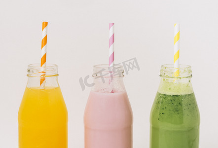 夏天饮料吸管摄影照片_各种美味水果冰沙瓶带吸管