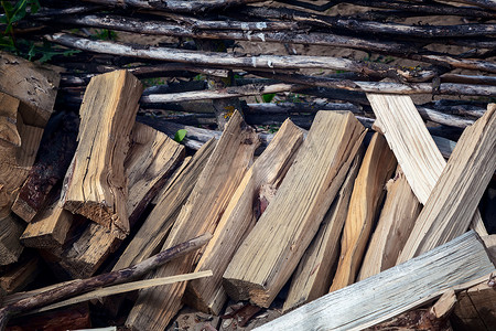 木头堆摄影照片_柳条栅栏附近的一堆木头
