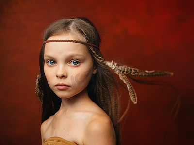 阿根廷绿檀摄影照片_头发里有一根羽毛的女孩野蛮原住民萨满印第安部落