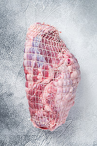 羊腿肉摄影照片_屠宰台上的无骨羊腿肉。