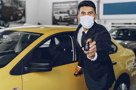 男汽车经销商在工作场所戴着防护医用口罩