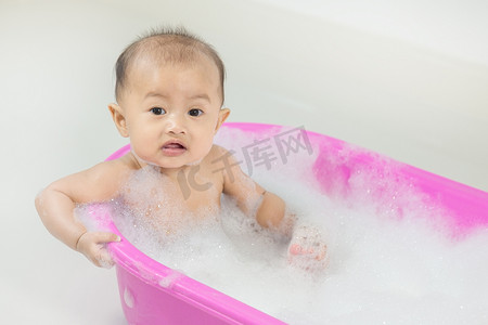 宝宝在浴缸里洗澡，玩泡沫