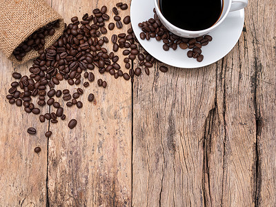 咖啡杯和咖啡豆在木制背景与复制空间，顶视图。