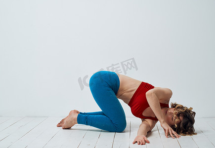 苗条女人摄影照片_瑜伽练习苗条女人蓝色紧身裤红色背心