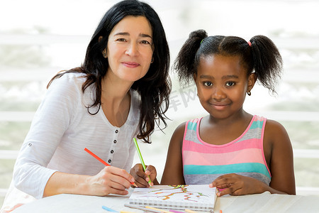 非洲小女孩和老师一起画画。