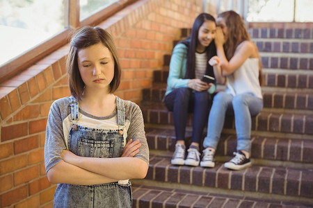 学校走廊摄影照片_学校朋友在学校走廊欺负一个悲伤的女孩