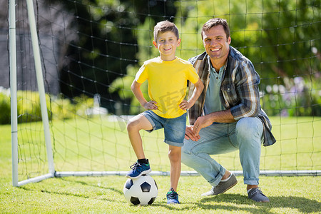 十里红妆摄影照片_阳光明媚的日子里，父亲和儿子在公园里踢足球