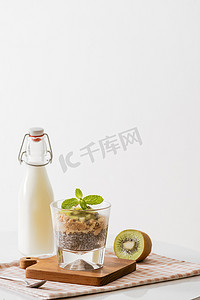 奇异果籽摄影照片_健康早餐，包括酸奶、坚果、猕猴桃和奇亚籽。