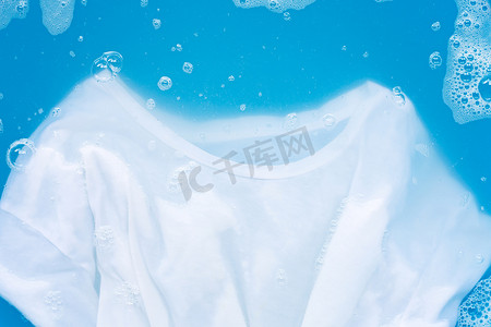 白T恤浸泡在粉状洗涤剂水中溶解，洗净