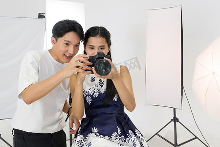 相机屏幕摄影照片_亚洲摄影师允许模特在相机屏幕上查看拍摄的照片