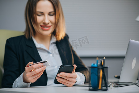 金融app摄影照片_妇女通过手机刷卡支付账单。