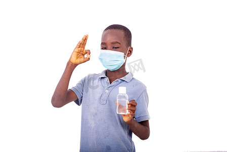 戴着医用口罩的小男孩拿着抗菌凝胶。