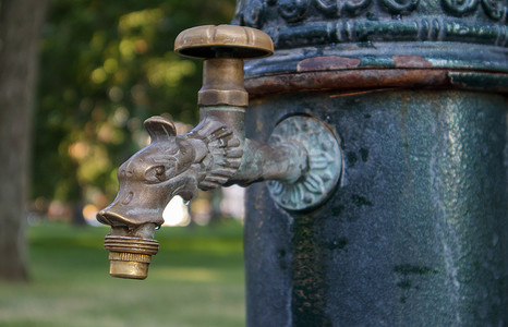 夏天公园里的水井、抽水系统、美丽金属青铜水龙头的特写和侧视图。