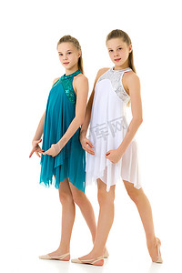 两个双胞胎姐妹穿着白色和蓝色运动连衣裙跳舞