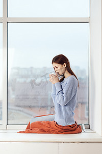 梦幻花纹摄影照片_窗边的女人梦幻般的样子在家休息舒适