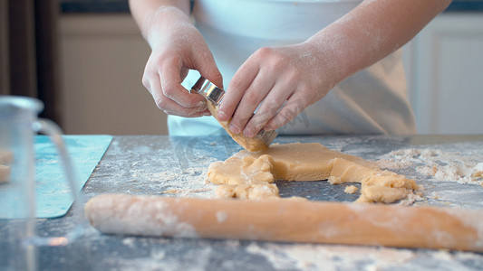厨师面团摄影照片_用曲奇刀做曲奇饼的女孩
