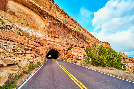 从隧道出来的路穿过沙漠中的大红色悬崖