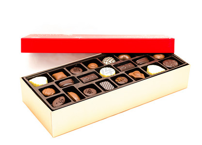 特写部分打开的巧克力盒，上面有喜庆的红盖和各种松露