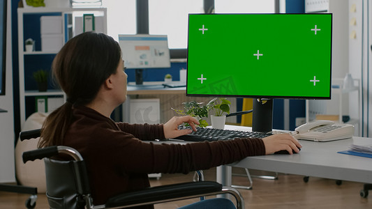 在台式电脑绿色模拟屏幕上工作的无效女员工