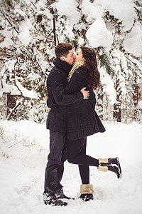 一个男孩和一个女孩穿着温暖的衣服和围巾在雪天散步