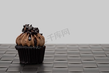 咖啡甜点摄影照片_复古背景中美味的巧克力迷你纸杯蛋糕，甜美的 des