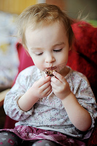 小孩眼睛摄影照片_吃巧克力的小孩女孩