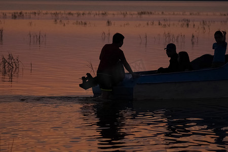 渔民摄影照片_船附近河上渔民的剪影。