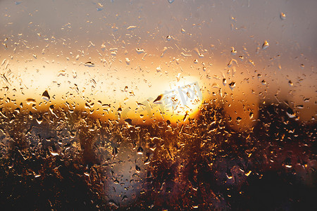 夕阳透过窗户与雨后的雨滴。
