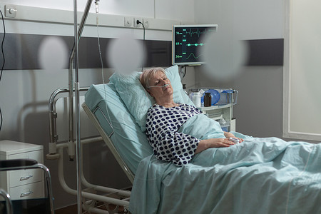 病房的老年女病人通过静脉注射管取药
