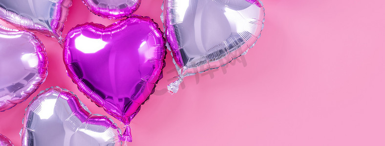 丁真摄影照片_情人节浪漫的设计理念-美丽的真实心形箔气球隔离在淡粉色背景、顶视图、平躺、摄影上方。