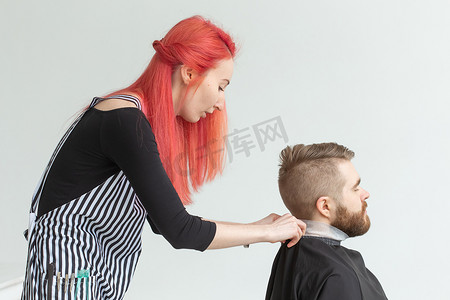美发师、造型师和理发店概念 — 年轻女发型师要给男人剪头发