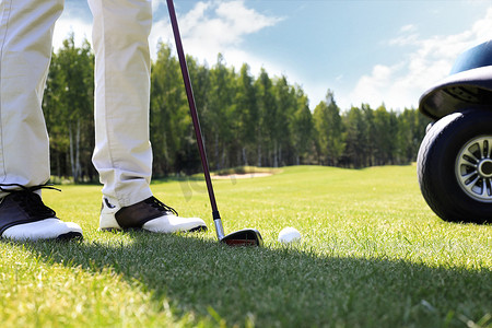 阳光明媚的日子里，用铁杆从球道上打高尔夫球。