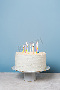 点燃火焰摄影照片_前视图点燃蜡烛生日蛋糕。