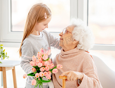 女孩向老妇人献花