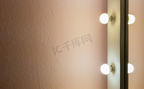 现代全新的扁平粉色墙壁，配有大落地镜上的两个灯泡，用于化妆和全身购物。