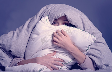 女人盖着毯子，担心失眠和压力。