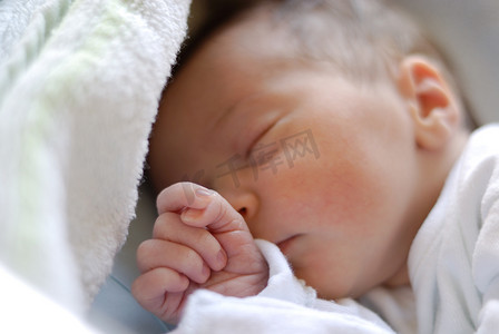 床上睡觉的婴儿摄影照片_新出生的女婴在医院床上睡觉