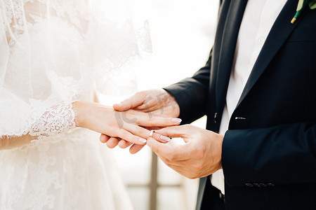 婚礼期间，新郎将戒指戴在新娘的手指上