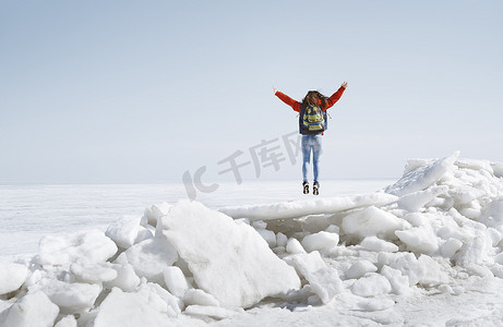 背包户外风景摄影照片_年轻成年女性在冰冷的风景中背着背包户外旅行