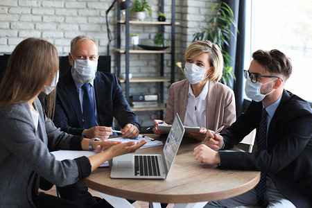 在冠状病毒流行期间，商界人士在举行会议演讲时戴着防护口罩。