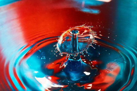 蓝色和红色的水，两滴水滴在空气中撞击，产生波纹和飞溅