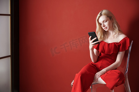 年轻成年女性在椅子上放松并使用智能手机