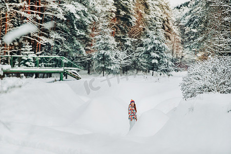 冬天森林里穿着灰色衣服的女人的肖像。新年白雪覆盖的森林里的女孩。