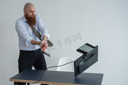 强调疯狂的商人使用斧头问题概念砸碎办公室的电脑。