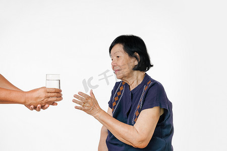70年代摄影照片_老妇人从护理人员那里得到一杯水和她的药片