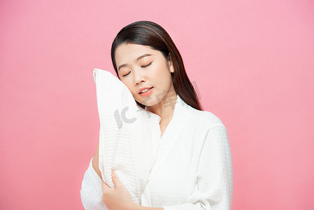 亚洲女性正在用干毛巾擦脸。