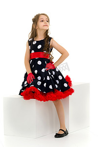 穿着圆点连衣裙、红色手套和蝴蝶结的女孩站着看着阿瓦。