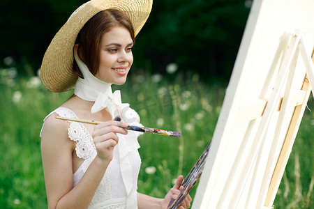 女艺术家用调色板观看自然画作